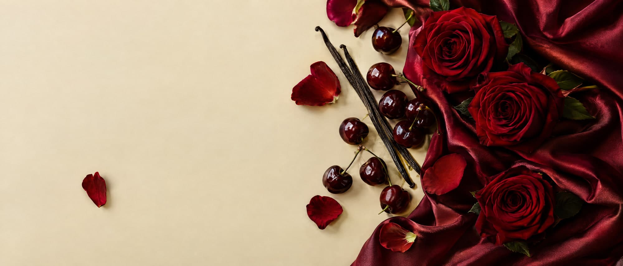 Seda vino con rosas rojas, pétalos, cerezas y vainas de vainilla sobre fondo beige